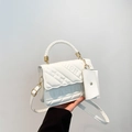 Weiße Stepptasche mit FASHION-Prägung und gewebtem Griff in der Seitenansicht - Weiß