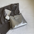 Silberne Metallic-Schultertasche mit Schleife und Wolkenanhänger auf grauem Blazer - Mit Anhänger / Silber