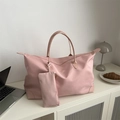 Borsa tote in nylon rosa con piccola pochette coordinata su scrivania moderna - Rosa