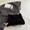 Fashionable black faux fur tote bag with leather handles in a stylish minimalist setting - Black