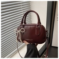 Detail of burgundy PU leather handbag with pearl bow charm and metal zipper - Burgundy