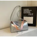 Dettaglio borsa a tracolla cilindrica argento con accento cinturino rosa a contrasto - Argento/Rosa a Contrasto