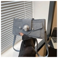 Detail der blau-grauen Wildleder-Schultertasche mit silberner Metallschnalle in Planetenform - Blau