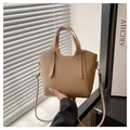 Close-up of khaki litchi grain leather bucket bag with top handles and shoulder strap - Khaki