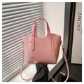 Detailed macro of pink lychee textured leather bag with gold metal hardware and strap - Pink