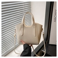 Macro view of creamy white lychee grain leather texture and metallic gold hardware detailing - White