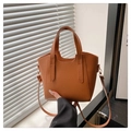 Detail of the brown lychee pattern leather texture on a chic bucket bag with gold hardware - Brown
