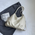 Minimalist beige soft leather tote bag with oval logo patch and silver hardware - White Without Charm