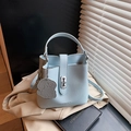 Hellblaue Eimer-Handtasche aus Leder mit silbernem Drehverschluss und Hundeanhänger - Blau