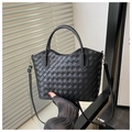 Detail shot of black woven tote bag featuring fine cross-weave texture and silver hardware - Black