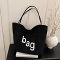 Minimalistische schwarze Canvas-Einkaufstasche mit weißem Schriftzug und viel Stauraum - Schwarz