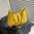 Vibrant yellow leather baguette bag with gold chain and buckle on a minimalist background - Yellow