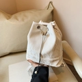 Bolso tipo cubo blanco con cordón, hebilla de mariposa y borlas de perlas en entorno chic - Blanco