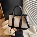 Beige canvas bucket bag with black leather trim and detachable shoulder strap - Black