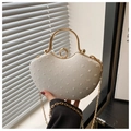 Close-up of cream heart evening bag with rhinestone ring clasp and golden handle - White