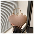 Detail of a pink sequined heart-shaped bag featuring a gold handle and diamond clasp - Pink