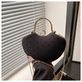 Detail of black heart-shaped handbag with textured fabric and golden ring clasp - Black