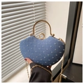 Close-up of heart-shaped denim bag featuring gold metal handle and rhinestone clasp - Blue