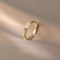 Anillo estilo bambú dorado con piedra ópalo blanco y detalles brillantes - Estilo de Bambú de Ojo de Gato Dorado