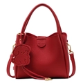 Red lychee texture leather bucket bag with top handles and a cute dog charm accessory - Red
