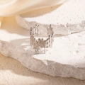 Unregelmäßiger Ring mit flüssiger Metalltextur in Silber auf Stein und Seide - Weißgold
