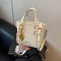 Chic cream white crossbody bucket bag with gold hardware and woven rope charm detail - Charm / White