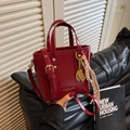 Fashionable wine red glossy bucket bag with golden charms and detachable shoulder strap - Charm / Burgundy