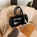 Fashion black patent leather Kelly bag with pearl heart pendant on casual sofa background - Without Pendant / Black