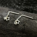 Elegant silver star tassel earrings with chain drop design on a dark textured rock background - Double Hollow Star Ear Thread