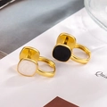 Dettaglio ravvicinato di orecchini a cerchio dorati con intarsio in smalto bianco e nero - Fibbia per Orecchio a Doppia Faccia Bianca e Nera (Colore Oro)