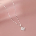 Minimalist silver cross pendant necklace with four zircons on pink silk fabric background - Cross Necklace (Stainless Steel White Gold Plated)