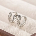 Detail of 6mm silver twist hoop earrings with pavé cubic zirconia on a beige display - Silver Twisted Zirconia Huggie 6mm (EH7401YS)