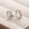 Macro shot of 8mm twisted silver huggie earrings with pavé zircons in a jewelry box - Silver Twisted Zirconia Huggie 8mm (EH7402YS)