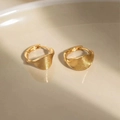Macro shot of gold-plated hoop earrings with wavy texture on a white ceramic tray - Gold Shell Texture Wave Huggie (EH791JS)
