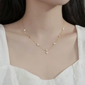 Close-up of a gold four-leaf flower necklace with zircon stones on a model's neck - Gold Flower Zirconia Necklace (DD-TN28-gold)