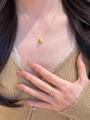 Primo piano di una collana con ciondolo a barile d'oro e anello su una modella - Collana a Stella Spazzolata in Zirconia Bianca (Colore Oro)