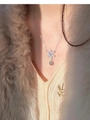 Dettaglio collana con fiocco di neve in zircone e perla su maglione lavorato beige - Stile Fiocco di Neve Perla Grigia