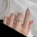 Adjustable silver star ring featuring woven band and sparkling star charms on hand - Meteor Style
