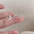 Orecchini a perno con tre fiori in argento e chiusura a vite mostrati sul dito - Gancio per Orecchio a Fiore - Stile a Vite (Rame Placcato Argento)