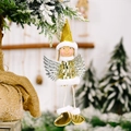 Sparkly gold angel pendant with silver wings on a snowy Christmas tree branch - Gold