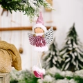 Pink sequin Christmas angel girl ornament with silver wings hanging on a pine tree - Purple