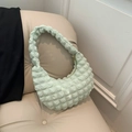 Minzgrüne Handtasche mit Blasenstruktur im Vintage-Stil auf einem beigen Ledersofa - Grün