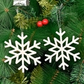 Set of two white glitter snowflake ornaments hanging on a green Christmas tree branch - White Hollow Snowflake Style