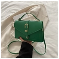 Détail du sac à bandoulière vert foncé avec boucle dorée et texture de cuir synthétique fin - Vert