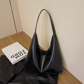 Minimalist black leather tote bag with large capacity on a modern wooden background - Black