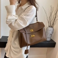 Elegante borsa a spalla in pelle marrone con chiusure girevoli dorate e un manico - Marrone