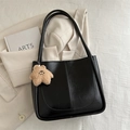 Vintage black faux leather tote bag with a beige plush star pendant on table - With Plush Charm / Black