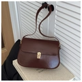 Detail of dark brown glossy shoulder bag featuring a gold metallic clasp and vintage leather texture - Coffee
