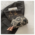 Nahaufnahme goldener Blumenstickerei auf schwarzer Stofftasche mit feiner Goldkette - Schwarz