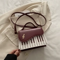 Burgundy contrast piano theme crossbody bag featuring gold musical note and keyboard detail - Red